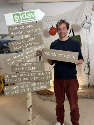 Tobias Krell, Moderator des Films, hält ein Schild in der Hand. Auf dem Schild steht 